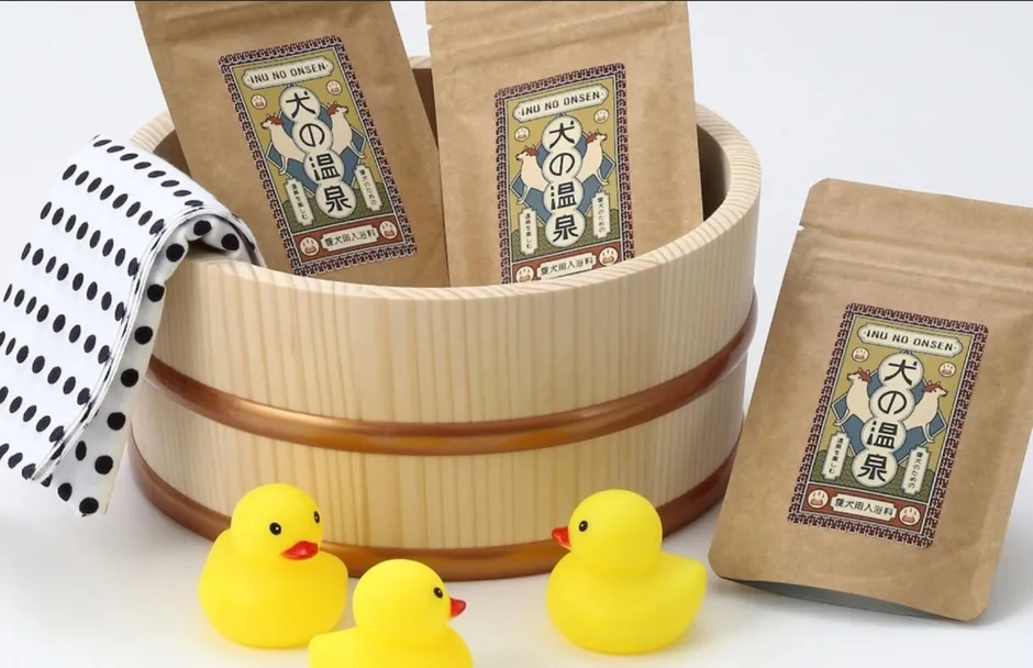 犬の温泉の入浴剤とアヒルの置物、手ぬぐいが写った写真