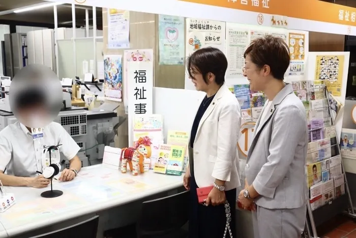 福祉事務所と思われる場所で、2人の女性が受付の人と話をしている様子