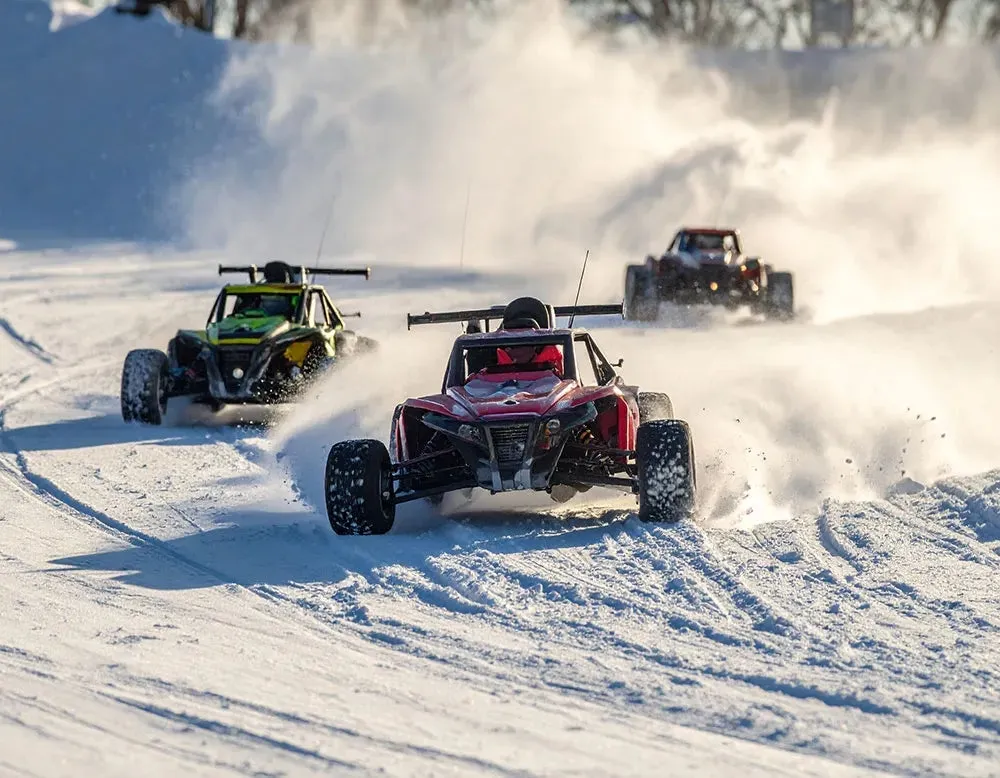 雪の中でラジコンカーがレースをしている様子。
