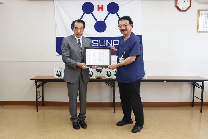 2人の男性が、賞状のようなものを手に持っている写真