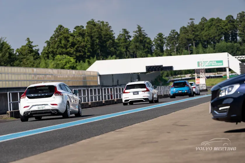 サーキットを走行するボルボ車を捉えた写真。様々な車種が連なっており、イベントの様子が伺える。