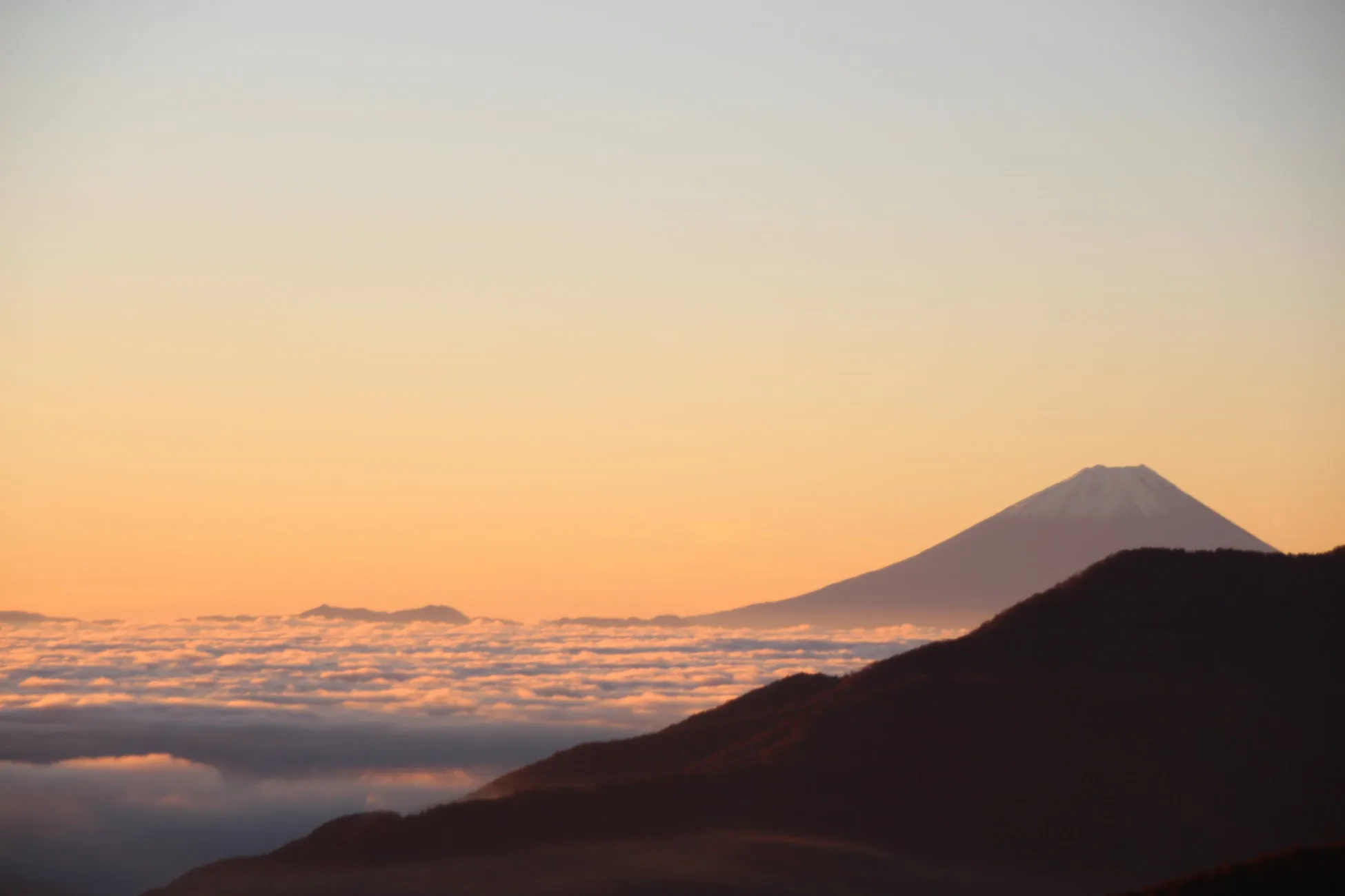 朝焼けに染まる富士山と雲海の風景。