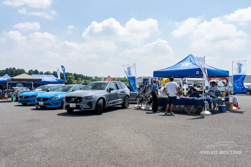 ボルボのイベントの様子を捉えた写真。様々なボルボ車が展示され、イベントブースや人々も写っています。