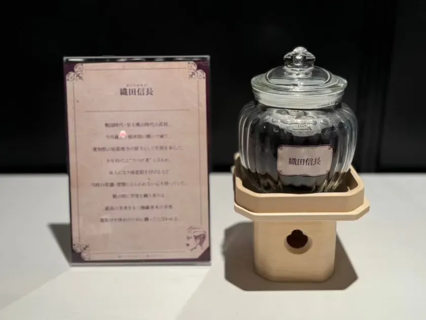 織田信長の文字が書かれたラベルが付いたガラス瓶と、織田信長に関する情報が書かれたカードが置かれている写真です。