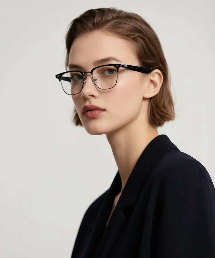 眼鏡をかけた女性のポートレート。彼女は黒いフレームの眼鏡をかけており、髪は短く、黒いジャケットを着ています。背景は白です。