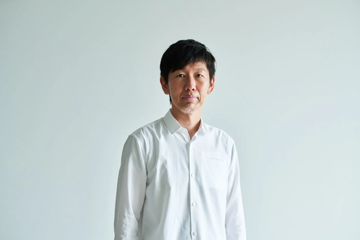 白いシャツを着たアジア人男性のポートレート。