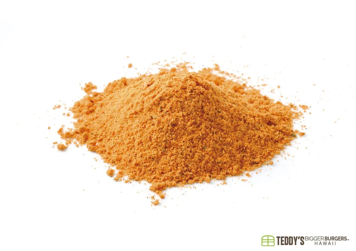 白い背景に山状に盛られたオレンジ色の細かい粉末が写っています。調味料やスパイスのように見え、右下には「TEDDY'S BIGGER BURGERS HAWAII」のロゴがあります。