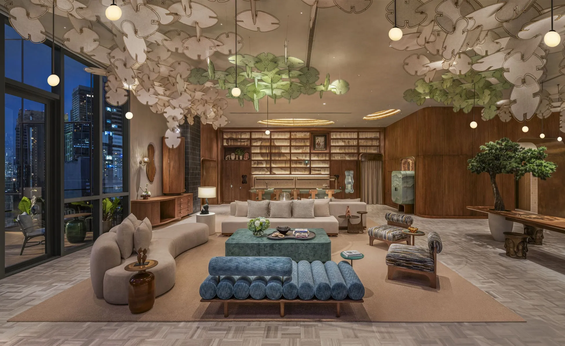 洗練されたリビングルーム。木材をふんだんに使用した内装で、天井にはユニークな装飾が施されています。大きな窓からは夜景が望めます。