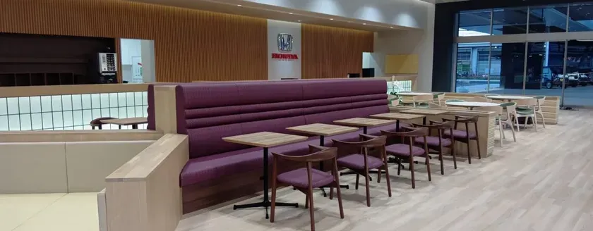 ホンダのショールームのカフェスペース。紫色のソファ席とテーブル、椅子が配置されている。