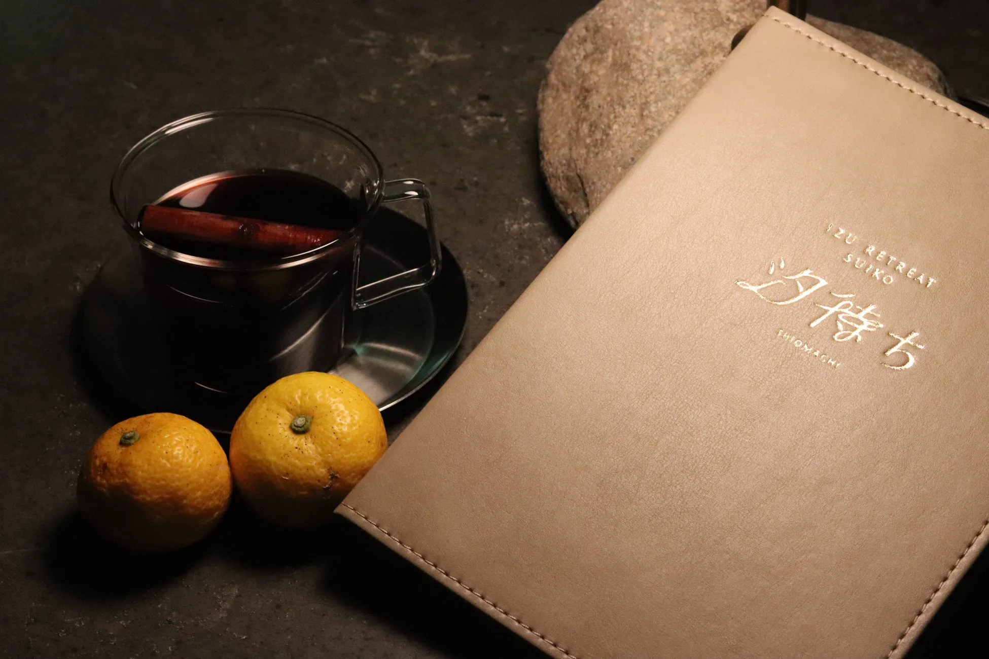 テーブルの上に、温かい飲み物とミカン、メニューが置かれている