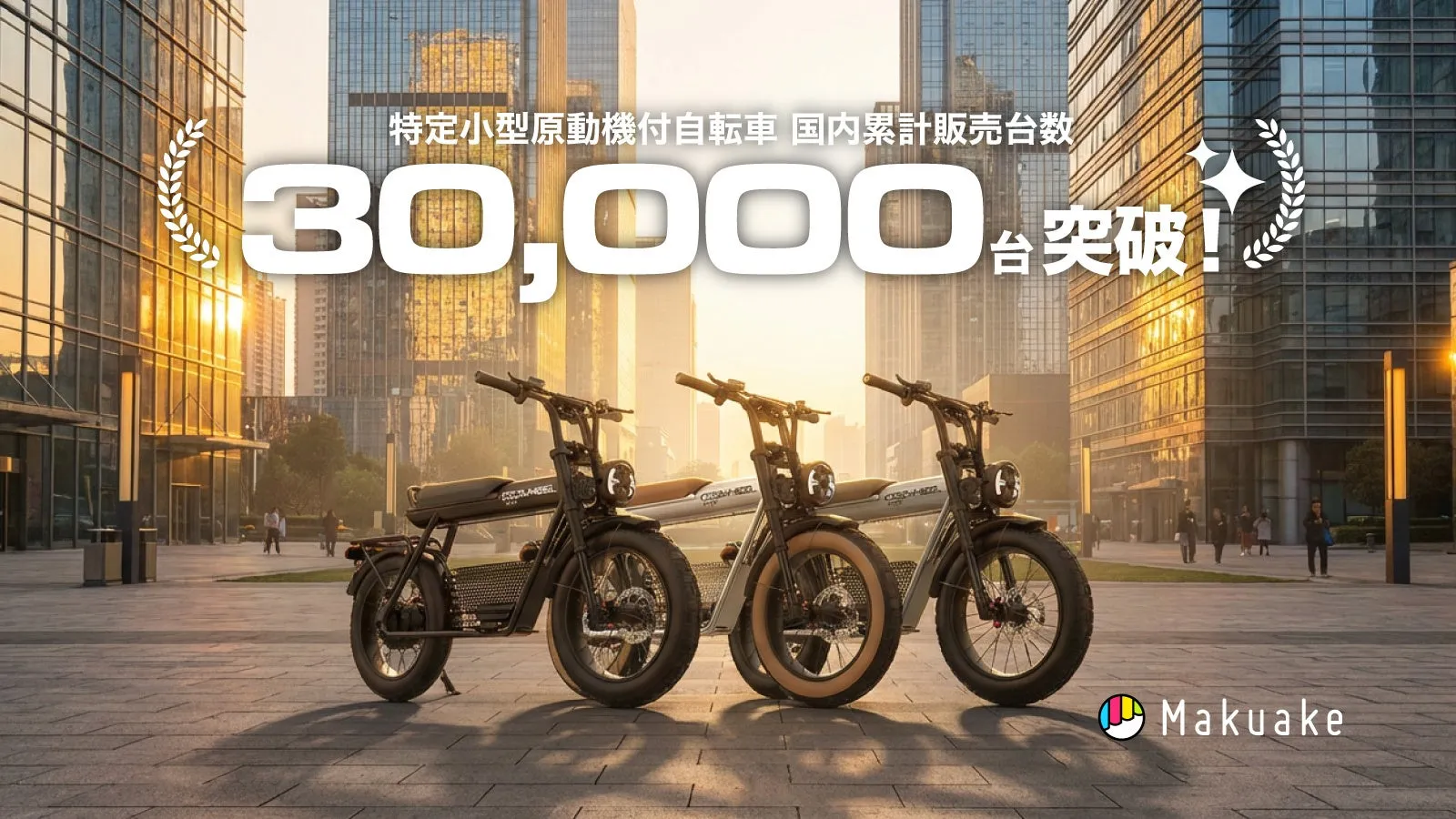3台の電動自転車が並んだ画像。背景には高層ビルがあり、都市の風景が広がっています。画像には「30,000台突破!」という文字と、Makuakeのロゴが入っています。