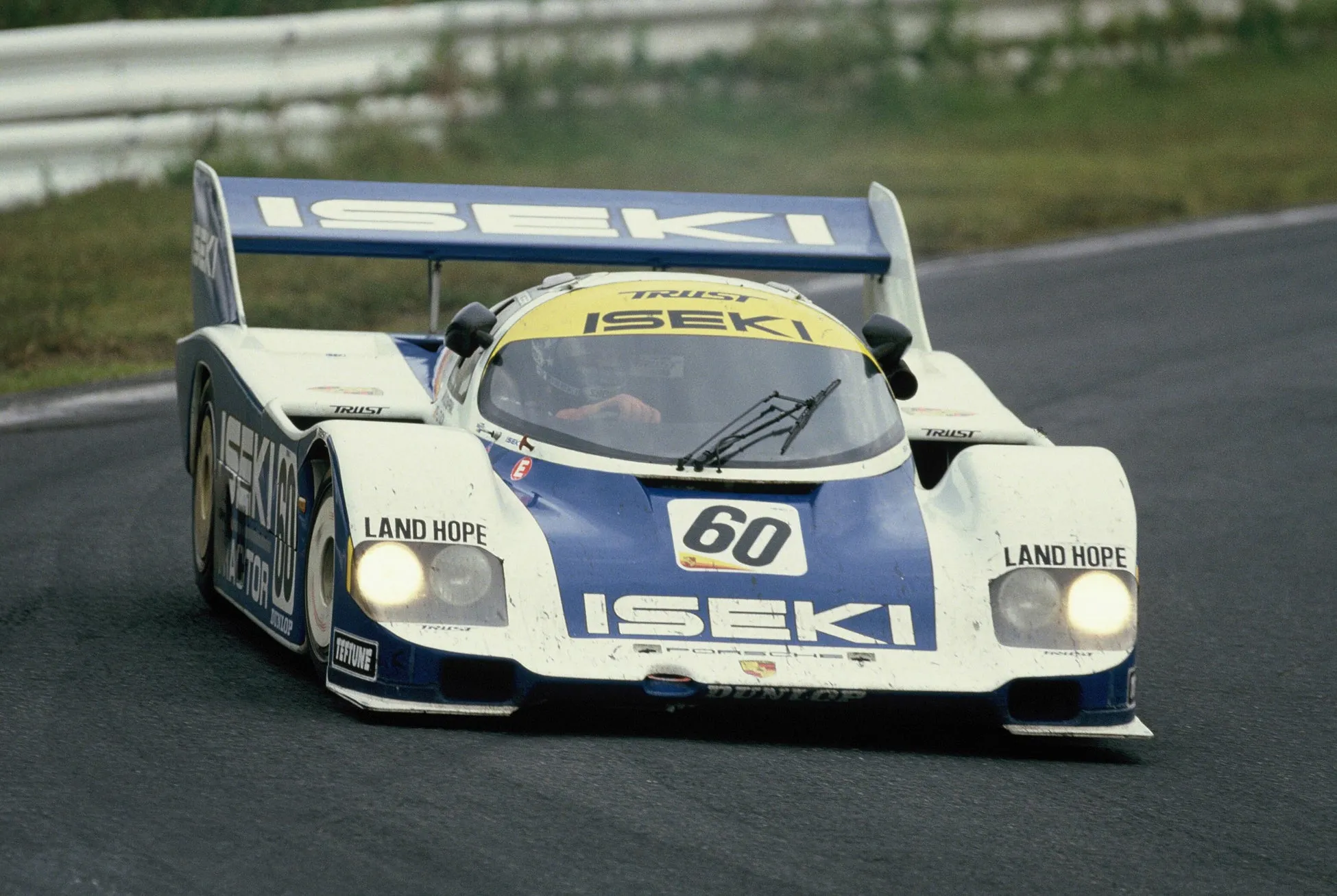 レーシングカーがレーストラックを走行している様子を捉えた写真です。車両は白と青を基調とし、ISEKI、TRUST、LAND HOPEなどのロゴが鮮やかに表示されています。ゼッケン番号60が大きく目立ちます。