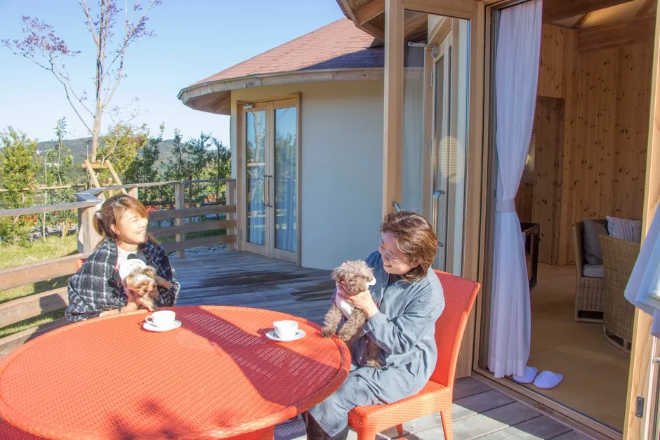 テラスで犬とくつろぐ女性たち