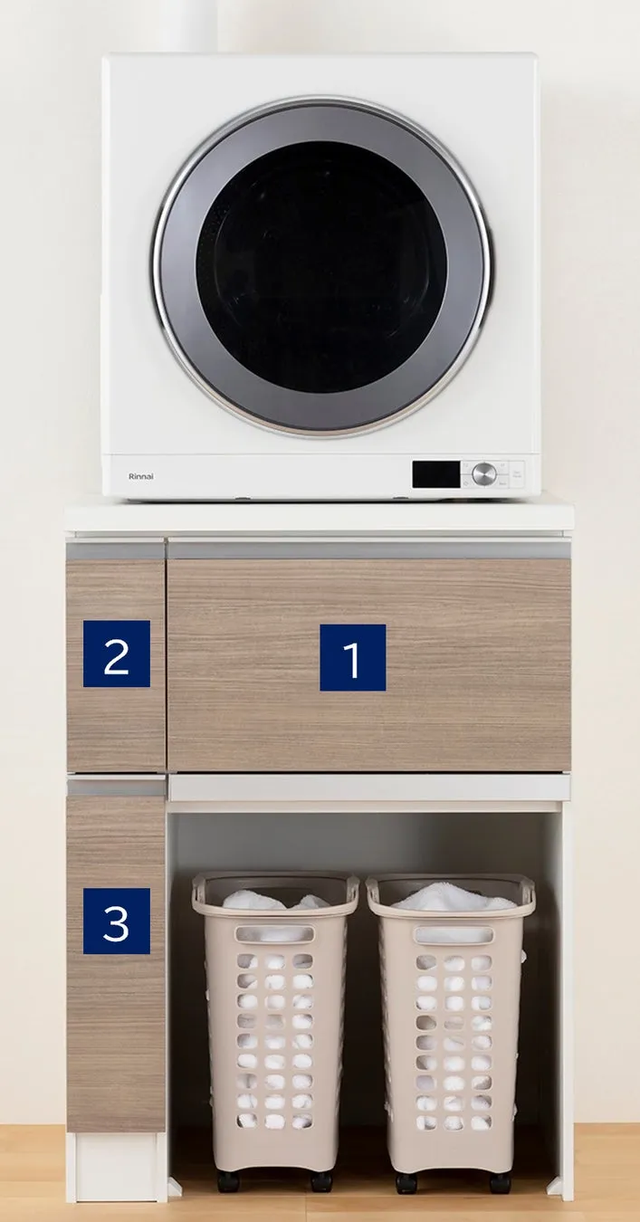 洗濯乾燥機と洗濯かごが配置されたランドリー収納の画像です。洗濯乾燥機は白を基調とし、木目調の収納と組み合わされています。洗濯かごには洗濯物が入れられています。