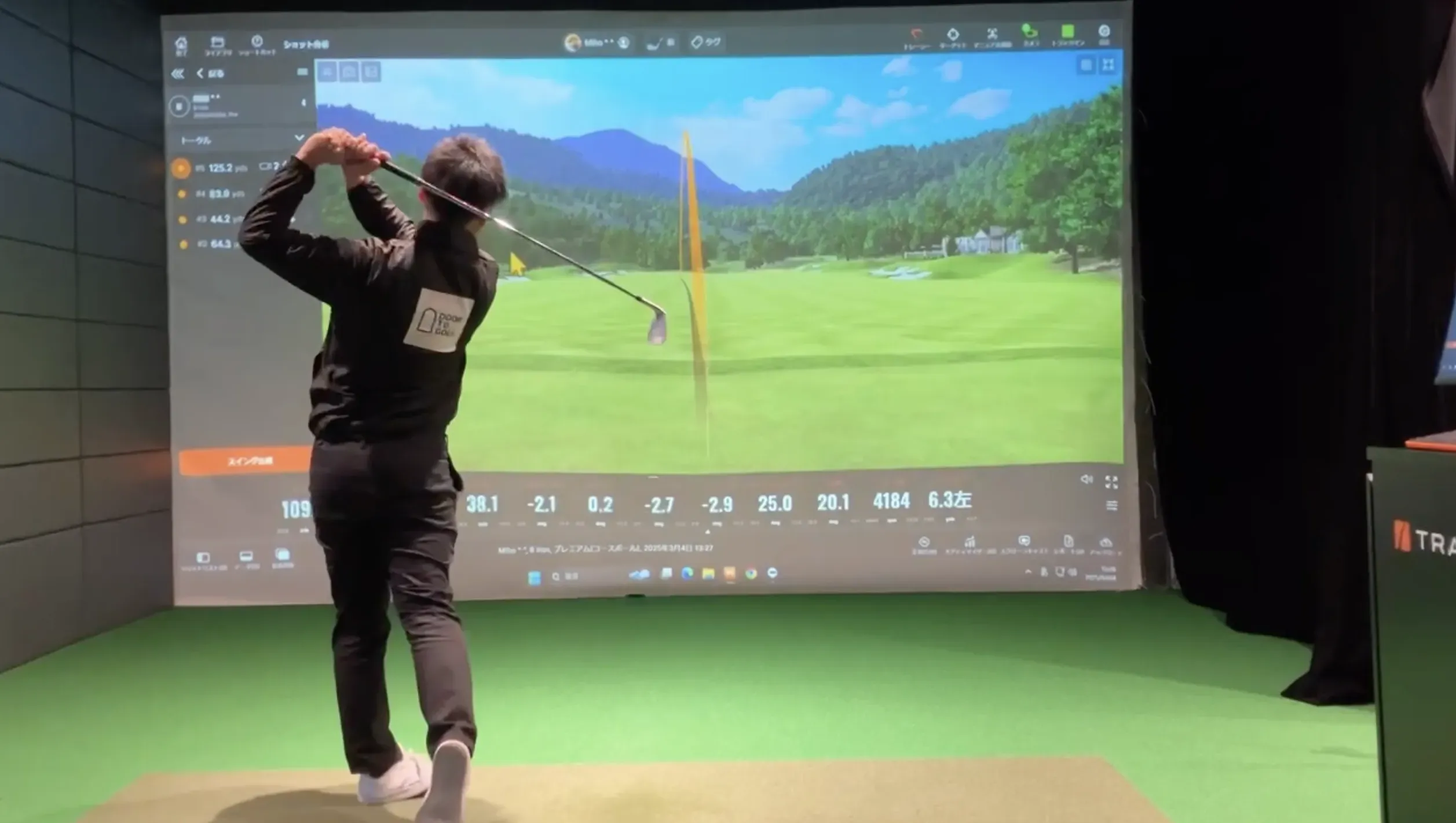 ゴルフシミュレーターでスイングする男性