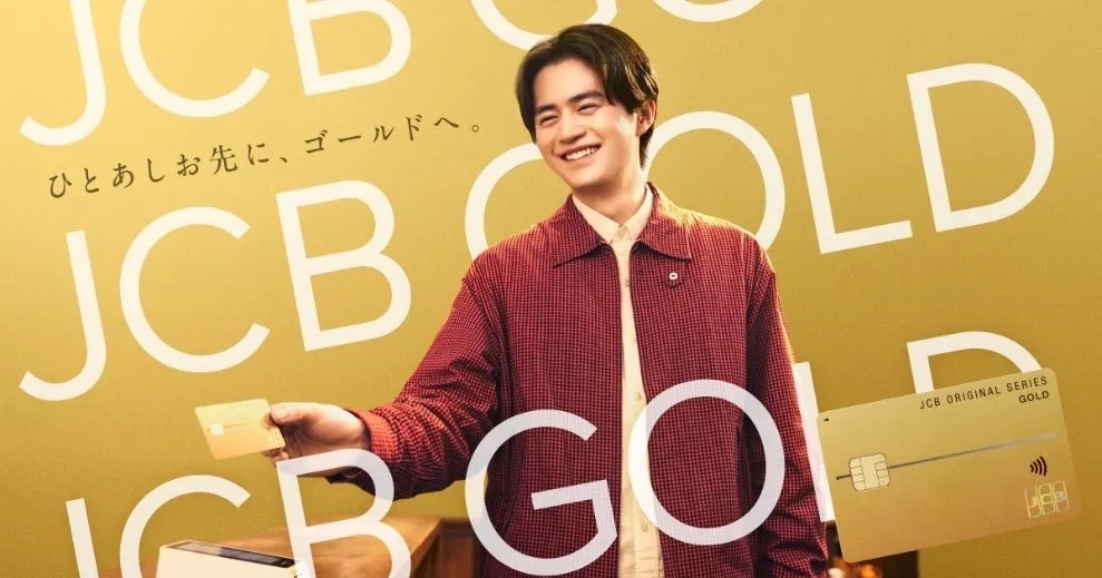 男性がJCBゴールドカードを手に笑顔で写っている広告画像