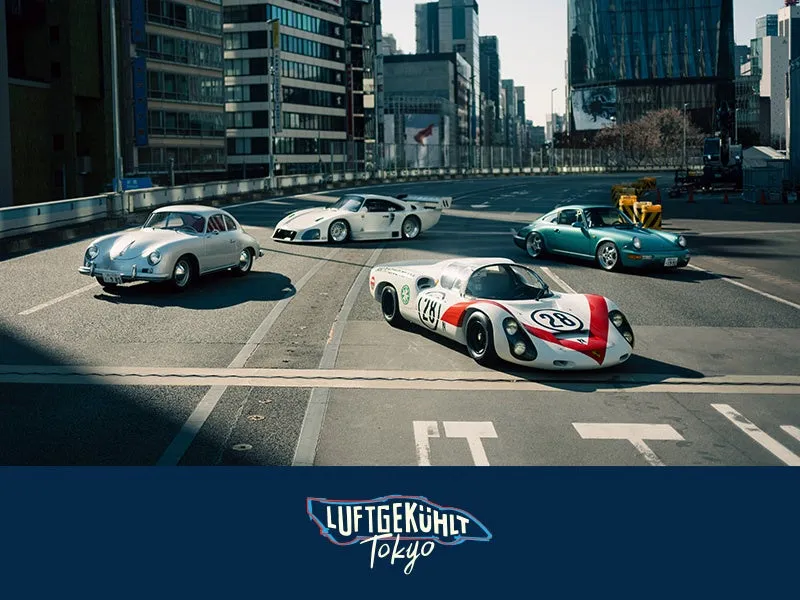 東京の街並みを背景に、様々なポルシェが並んでいる写真。