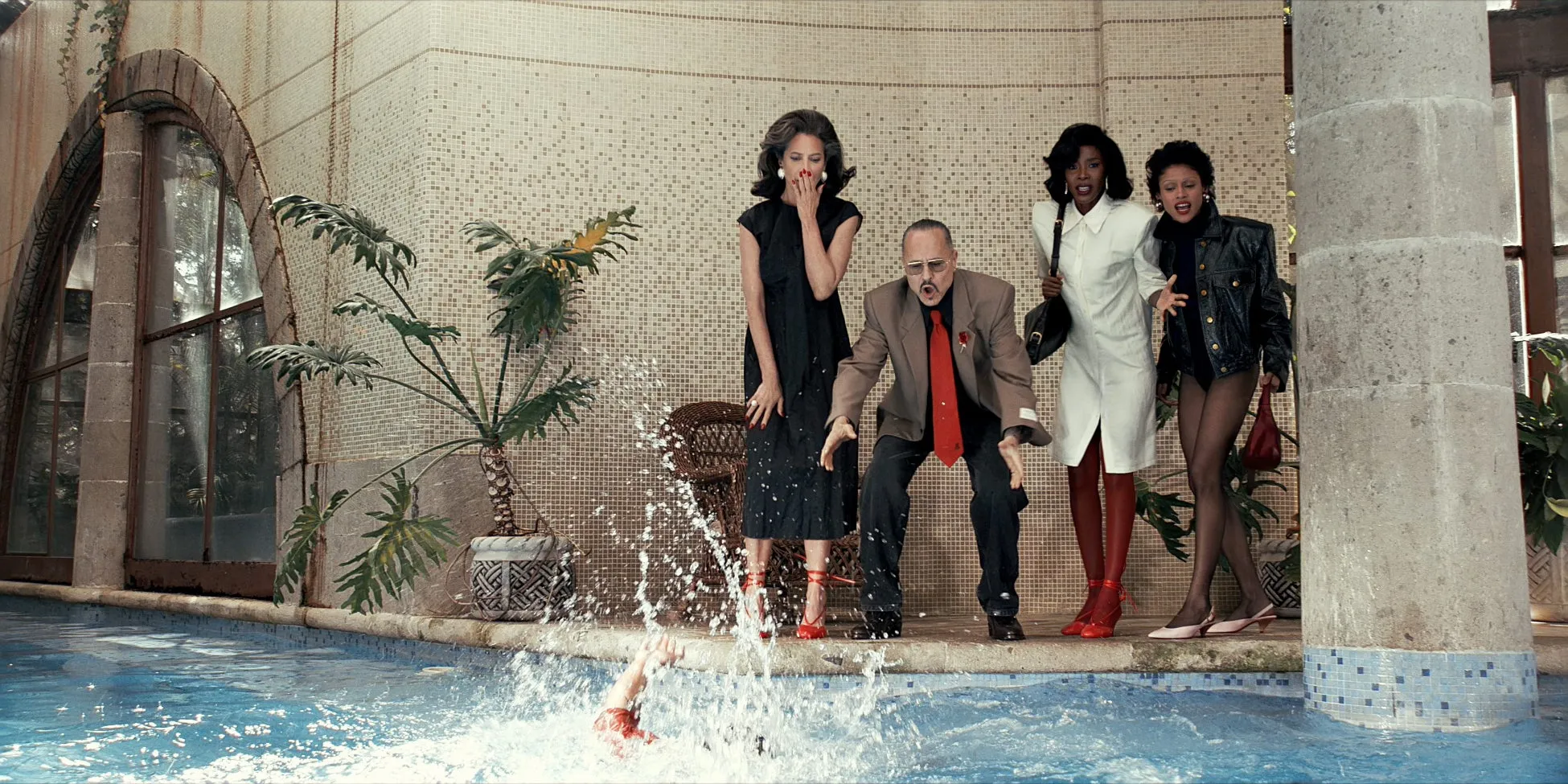 プールサイドで驚いた表情をする人々。誰かがプールに飛び込んだ様子。