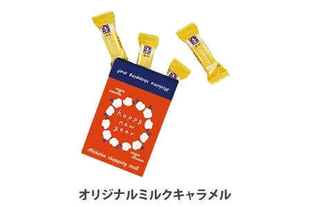 お菓子のパッケージの画像です。赤い箱に白い花のようなデザインが施され、「happy new year」と書かれています。箱からはキャラメルが飛び出しており、全体的に明るくお祝いの雰囲気が漂っている。