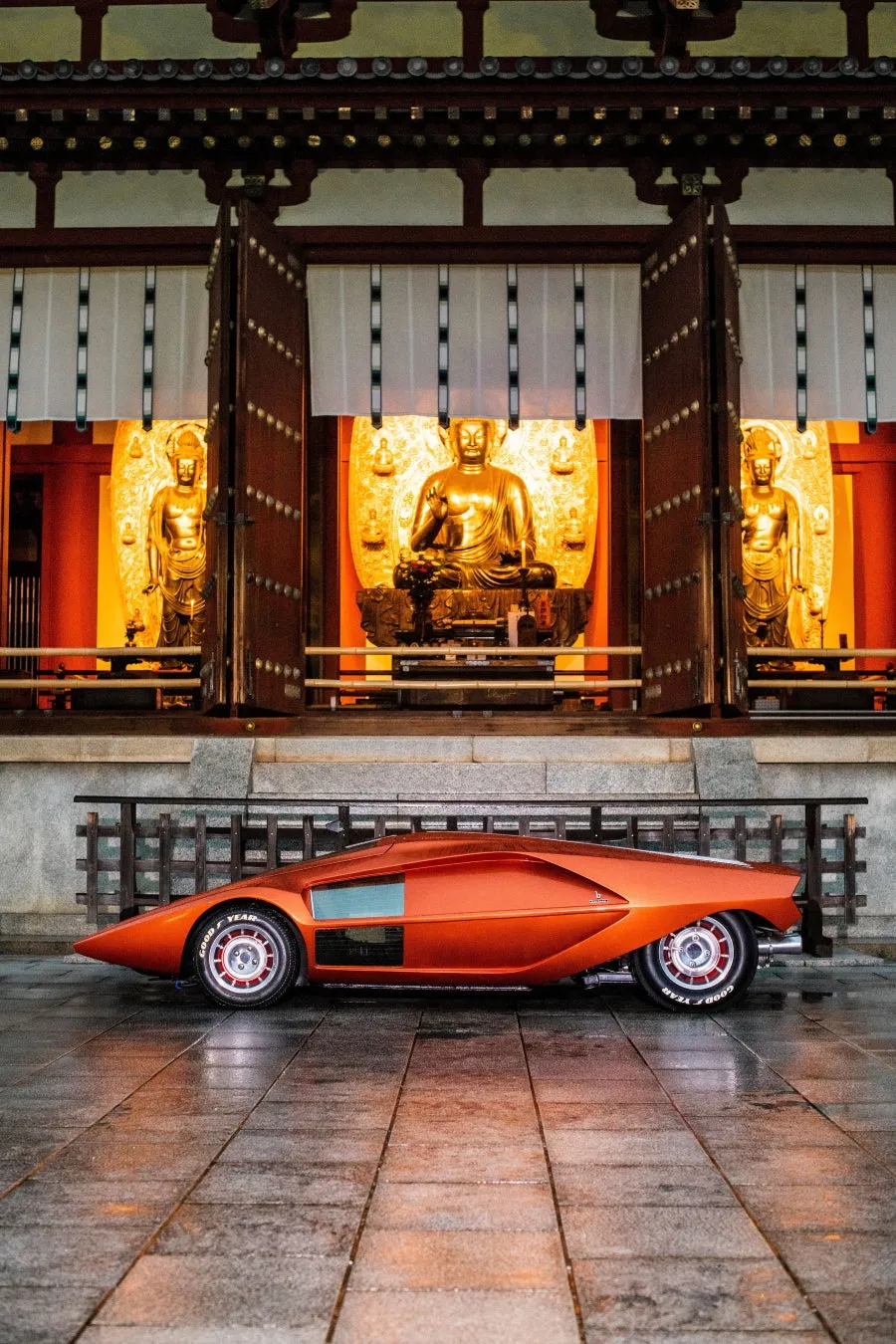 仏教寺院の前に停められたオレンジ色の車