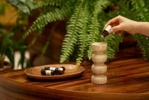 アロマオイルをディフューザーに垂らしている様子。日常に香りを取り入れる提案