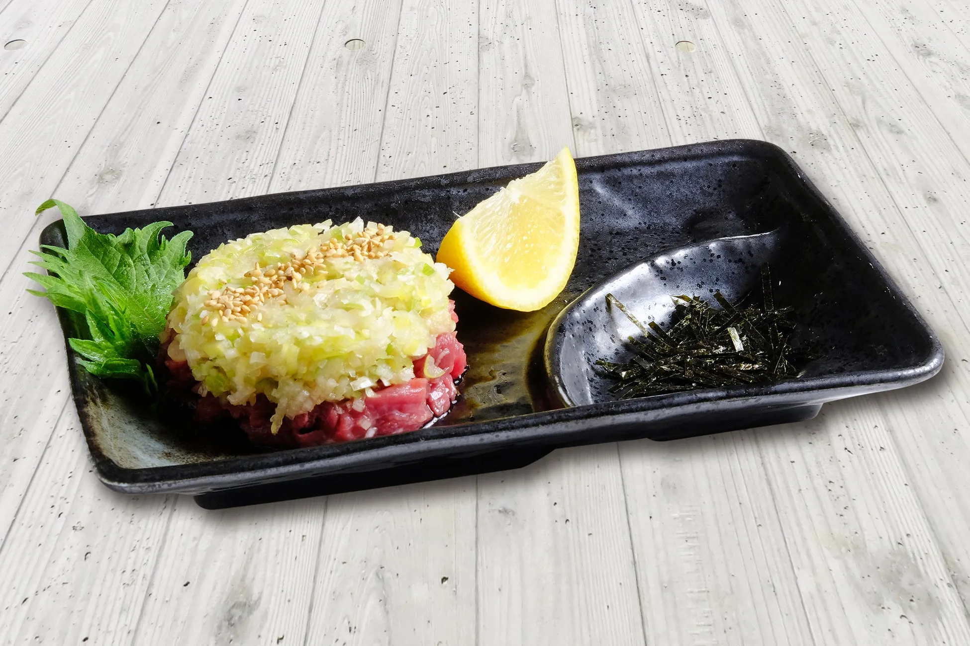 黒い長方形のお皿に盛られた料理