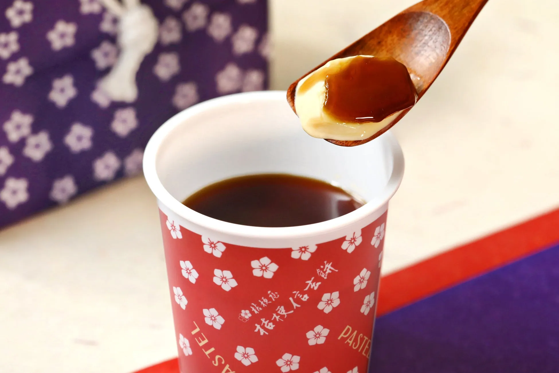 プリンとカラメルソースをスプーンですくっている様子