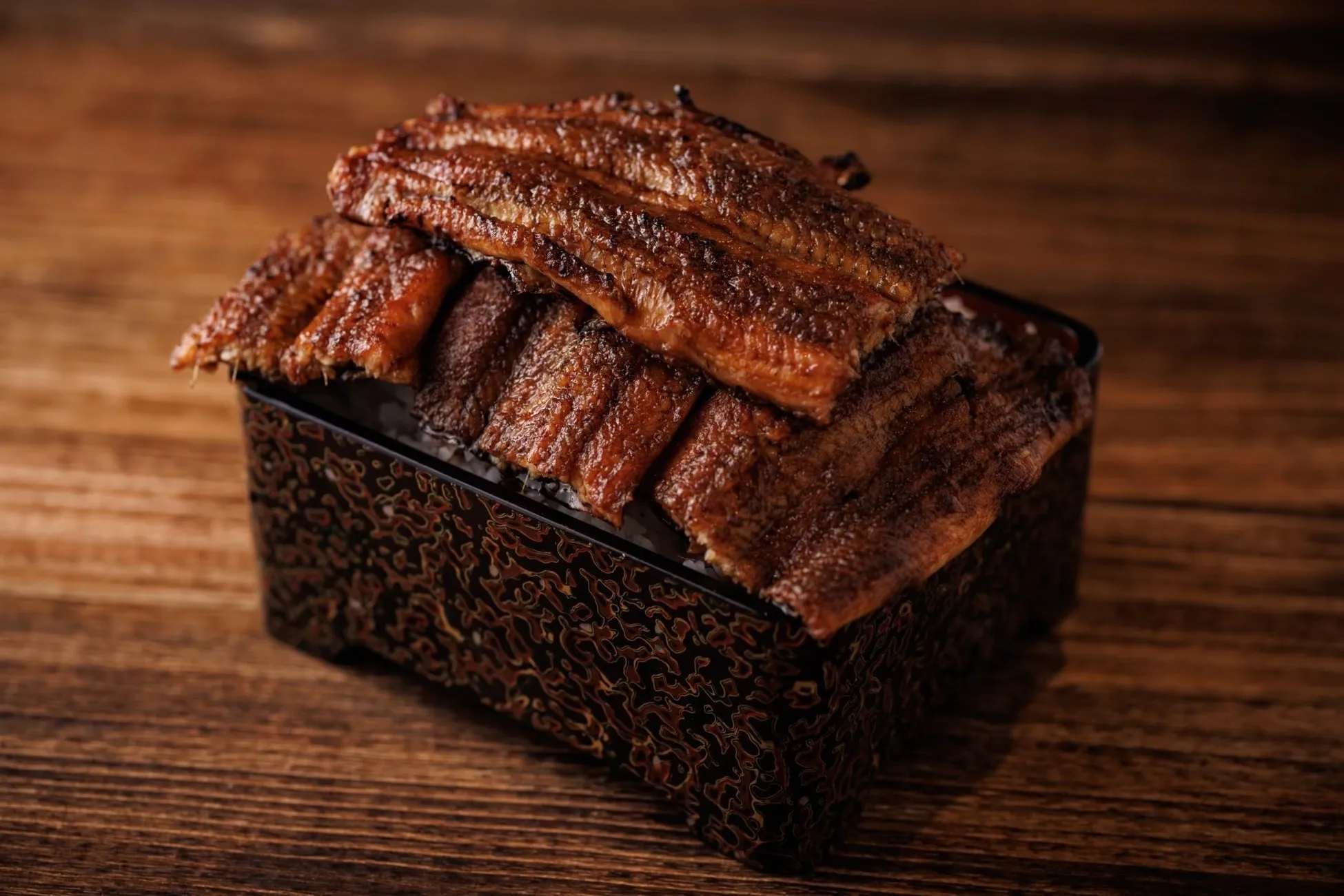 照り焼きにされたうなぎがご飯の上に盛り付けられたうな重