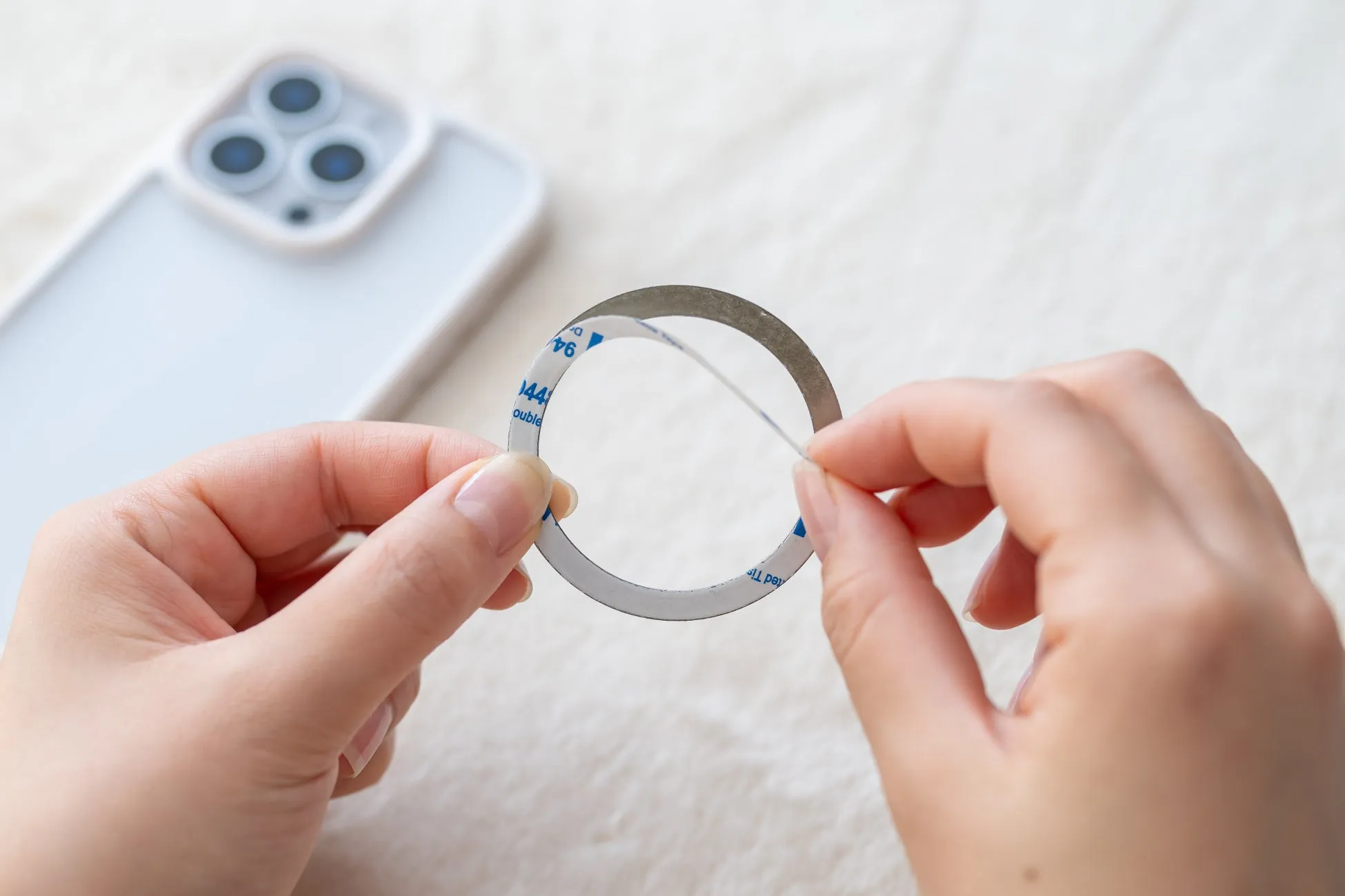 スマートフォンにリングを取り付ける様子