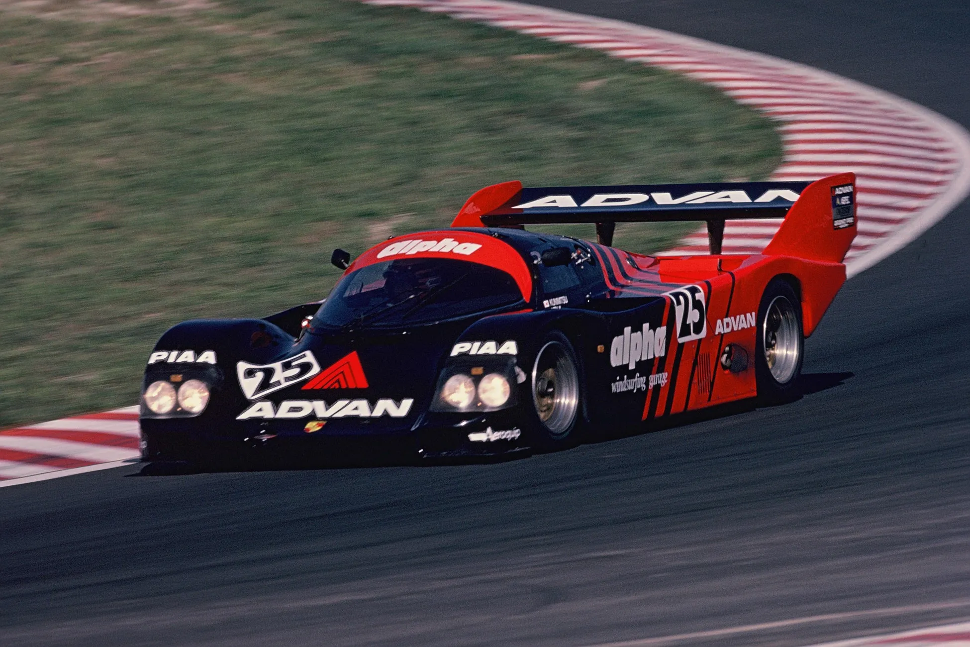 サーキットを走行するレーシングカーの写真。車体にはスポンサーのロゴや車番が大きく表示され、スピード感あふれる様子が捉えられています。