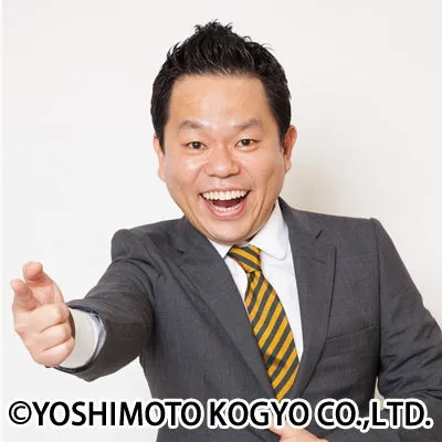 男性がスーツを着て笑顔で指を指している写真です。