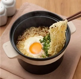 ラーメンの入った鍋から箸で麺を持ち上げている様子