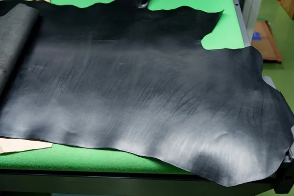 黒い革がテーブルの上に広げられている様子