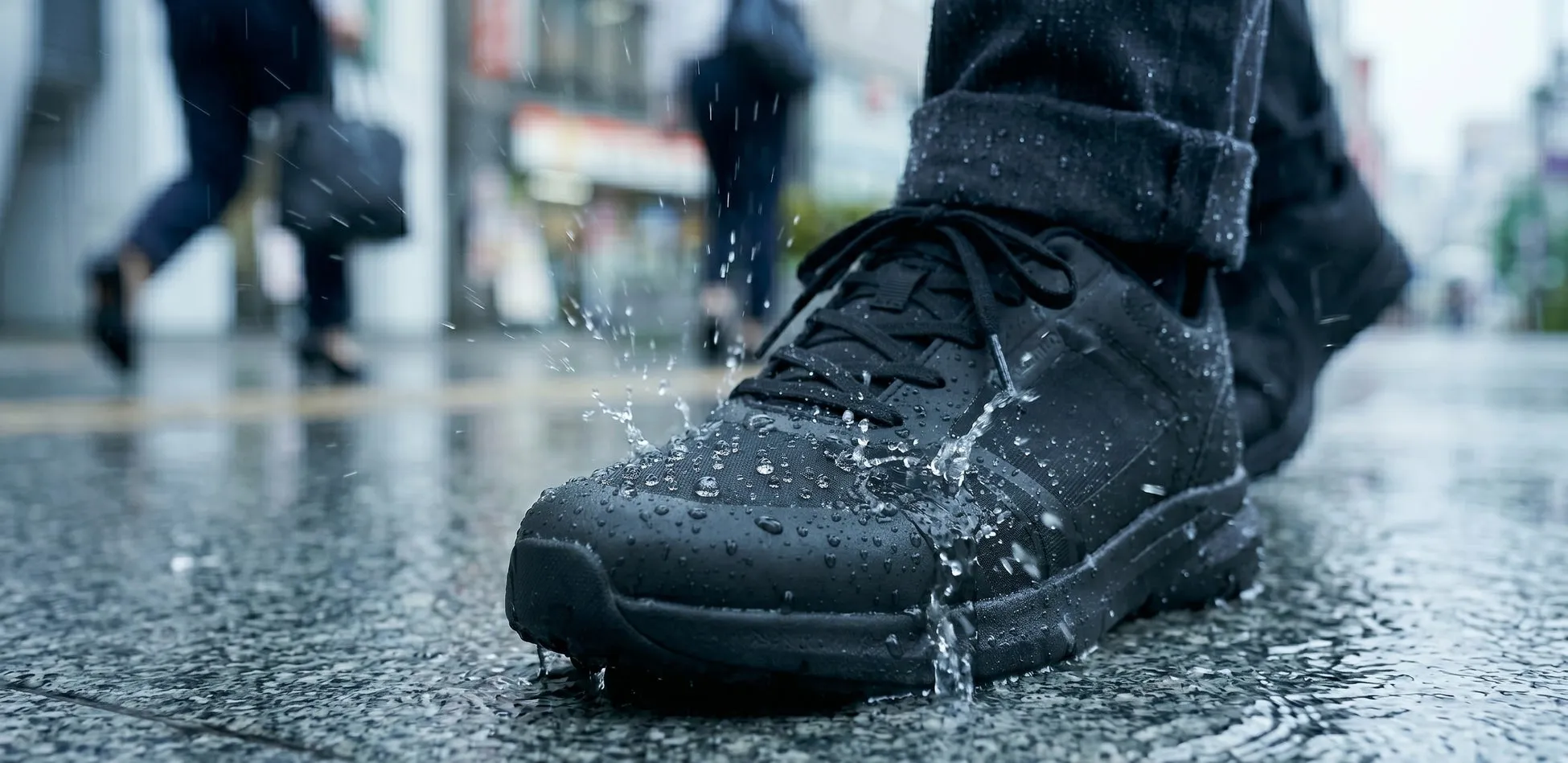 雨の中で黒いスニーカーを履いた足元のクローズアップ