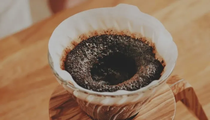 コーヒーをドリップしている様子を捉えた写真です。コーヒーフィルターにコーヒー粉がセットされ、お湯が注がれている様子が写っています。