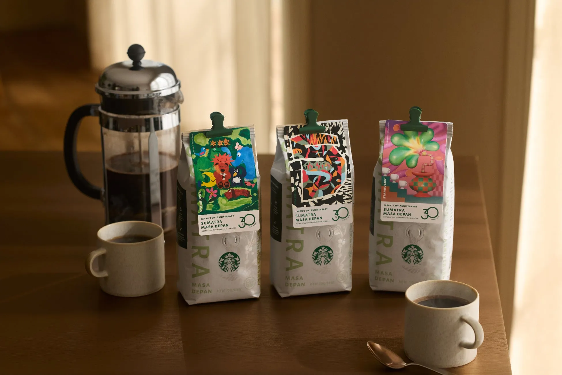 スターバックス日本上陸30周年を記念した「スマトラ マサ デパン」のコーヒー豆パッケージと、フレンチプレス、マグカップが写っています。